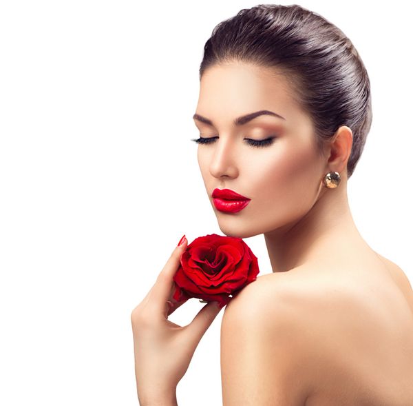 زن زیبایی با گل رز قرمز لب های سرخ و ناخن لوکس آرایشی زیبا و مانیکور مدل دختر مدل پرتره جدا شده بر روی زمینه سفید