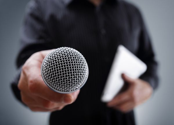 دست نگه داشتن یک میکروفون انجام مصاحبه کاری و یا کنفرانس مطبوعاتی