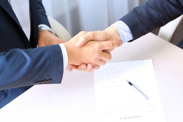 تصویری نزدیک از یک روابط شرکتی بین دو همکار پس از امضای قرارداد