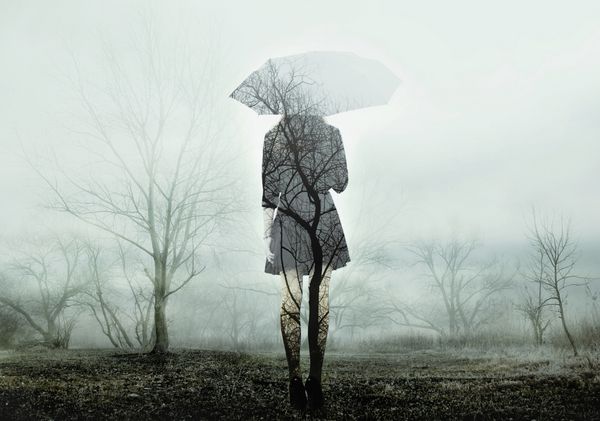زن با چتر ایستاده در زمینه با درختان تصویر با اثر قرار گرفتن در معرض دوگانه