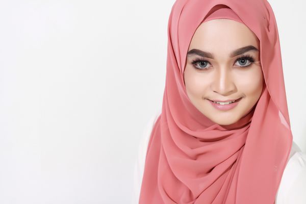 مدل زیبا مسلمان آسیایی مسلمانان با استناد به دیوار سفید با بیان متفاوت
