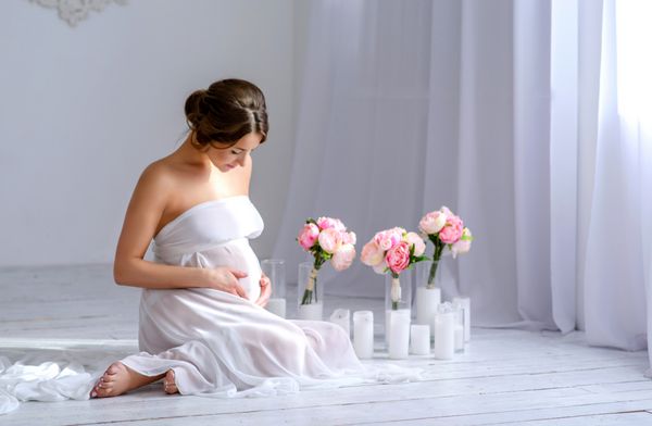 زیبا زن حامله در لباس سفید در مناقصه داخلی