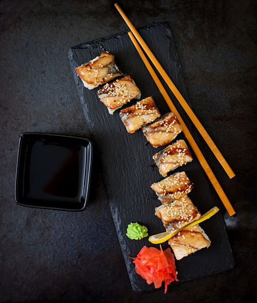 غذا های سنتی ژاپنی سوشی رول و سس روی پس زمینه سیاه مشاهده صفحه