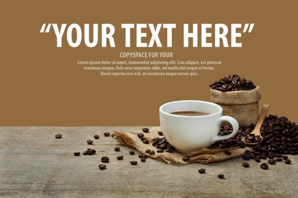 فنجان قهوه با دانه های قهوه روی میز چوبی و پس زمینه قهوه ای با فضای کپی برای متن شما چرخیده است