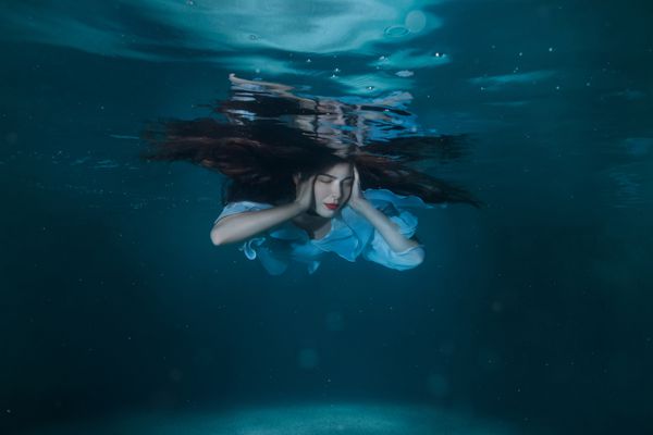 زن با موی بلند که در آب شناور است