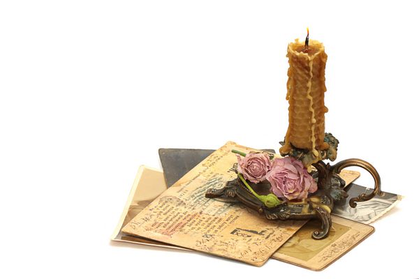 شمعدان برنز عتیقه شمع گل رز و نامه قدیمی جدا شده بر روی زمینه سفید