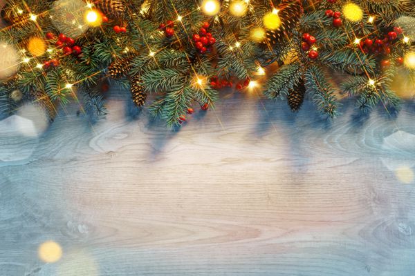 درخت کریسمس با چراغ طلایی در پس زمینه چوبی کریسمس مبارک و مبارک سال نو نمای بالا