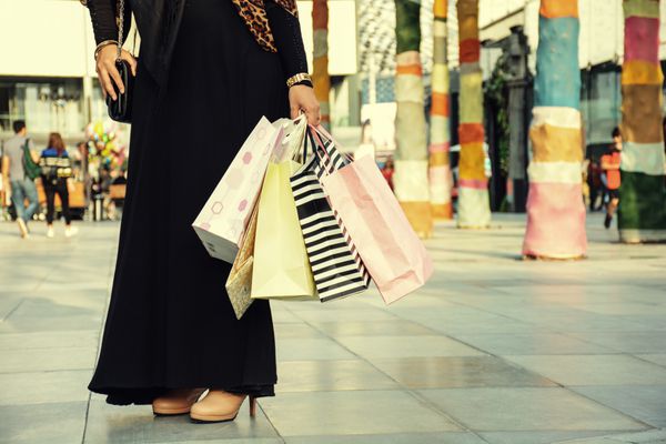 بعد از خرید روز نزدیک دختر جوان عربی حمل کیسه های خرید در حالی که راه رفتن در خیابان پوشیدن ابایا و حجاب