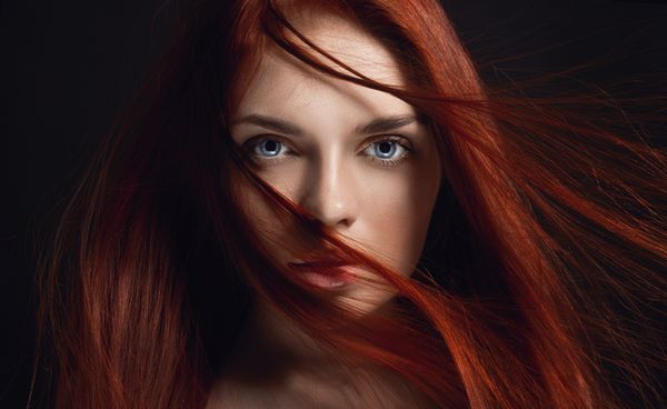 دختر مو قرمز زیبا با موی بلند پرتره زن کامل در پس زمینه سیاه و سفید موهای زرق و برق دار و چشم های عمیق زیبایی طبیعی پوست تمیز مراقبت از صورت و مو مو قوی و ضخیم گل