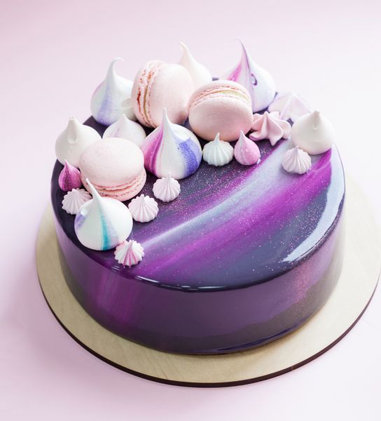 کیک موس مرسوم با لعاب آینه بنفش ماکارونی و نعناع تزئین شده است