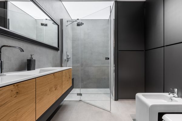 حمام مدرن خاکستری و سیاه و سفید با دوش بیت سینک و کابینت چوبی