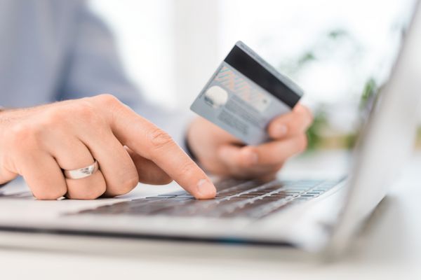 دست نگه داشتن کارت اعتباری و استفاده از لپ تاپ مفاهیم پرداخت و خرید آنلاین