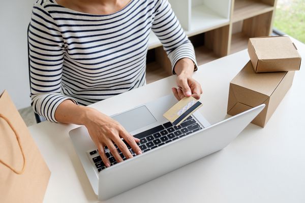 زن جوان داشتن کارت اعتباری و استفاده از کامپیوتر لپ تاپ مفهوم خرید آنلاین
