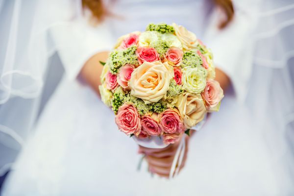 دسته گل عروسی با گل رز در دست عروس