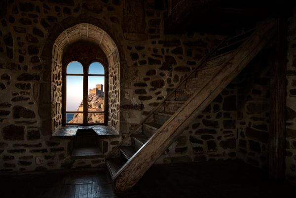 در داخل اتاق داخلی در قلعه قدیمی نردبان چوبی و پنجره عکس افقی