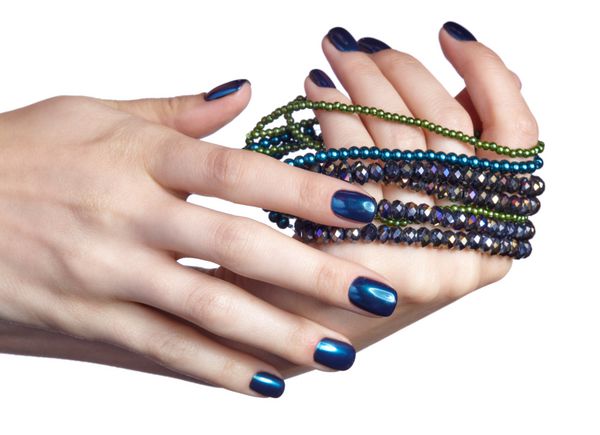 Woman with costume jewelery beads Female fingers with shiny blue nails manicure Girl