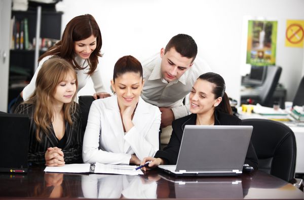 تیم کسب و کار موفق در حال کار بر روی یک کامپیوتر لپ تاپ است