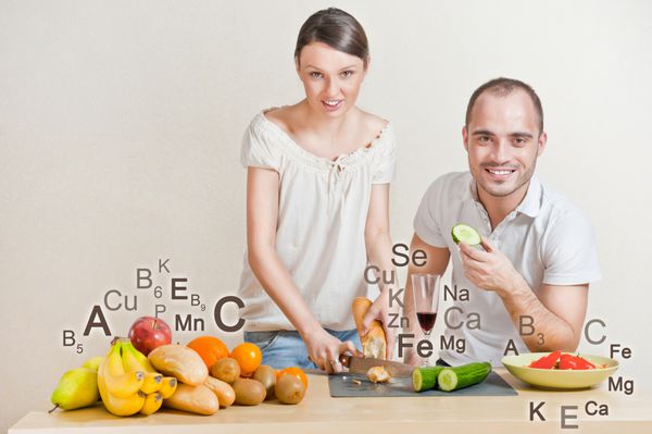 زن و شوهر دوست داشتنی پخت و پز رژیم غذایی متعادل فضای بزرگ علامت های ویتامین و میکرو عناصر در اطراف آنها هستند