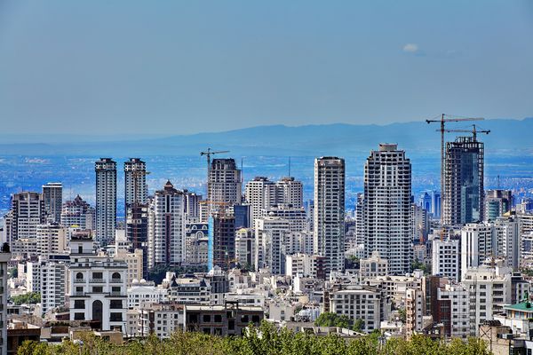 تهران ایران 28 آوریل 2017 نمای منطقه شهری با ساختمان های جدید و جرثقیل های ساختمانی در فاصله کوهها قرار دارند