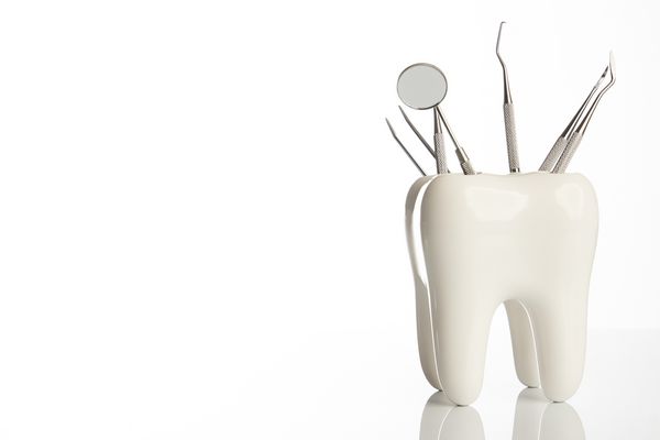 مدل دندانپزشکی دندانپزشکی با ابزارهای تجهیزات دندانپزشکی فلزی برای مراقبت از دندان دندان جدا شده در زمینه سفید با فضای کپی کلوزآپ مفهوم بهداشت دهان و دندان