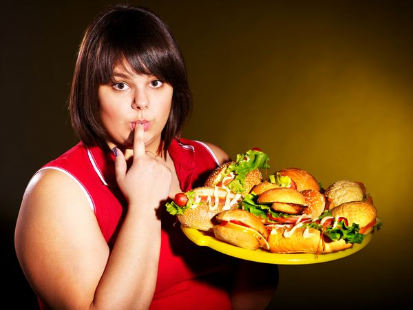 زن اضافه وزن که همبرگر می خورد
