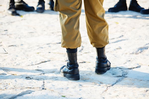 کفش و سرباز ارتش اسرائیل که در یک روز آفتابی روشن روی پاهای خود قرار می گیرد