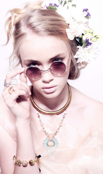 پرتره مد نزدیک نوجوان زیبا در گلهای جواهرات در مدل موهای در عینکهای صورتی جدا شده