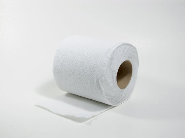 رول کاغذ توالت بر روی زمین سفید پشتی جدا می شود