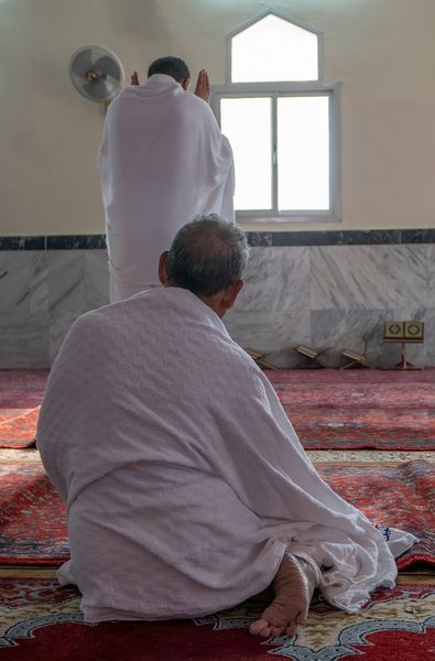 زائر مسلمان ناشناس در amp x27؛ ihram amp x27؛ لباس دعا می کند amp x27؛ احرام amp x27؛ لباس شامل دو لباس سفید بی نظیر است که در نظر گرفته شده است تا همه یکسان باشند