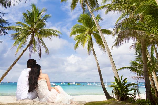 زن و شوهر جوان دوست داشتنی در زمینه دریا گرمسیری عروسی در ساحل