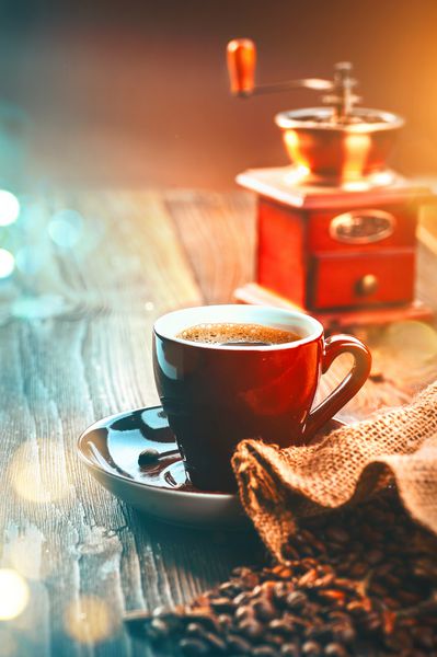 قهوه فنجان اسپرسو و چرخ قهوه عطر بو داده لوبیای قهوه روی میز چوبی طراحی هنری عمودی