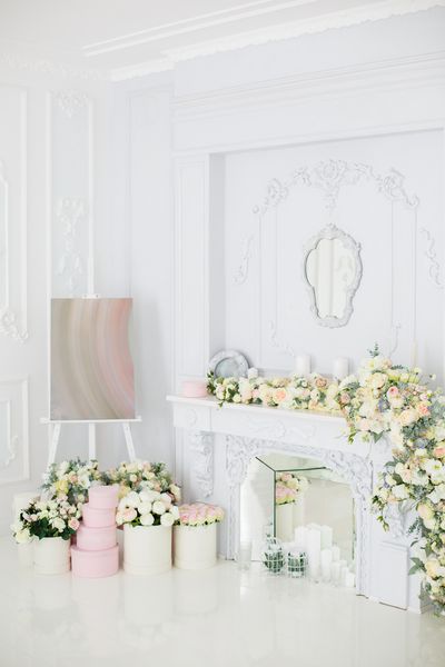 شومینه ای زیبا و پر از گل اتاق سفید زیبا با تزئینات جعبه های آسانسور و کلاه منطقه تزئین عروسی دکوراسیون پرنعمت در فضای داخلی