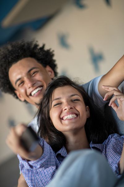 زن و شوهر سیاه جوان استراحت روی نیمکت و لبخند در دوربین