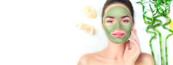 زن اسپا با استفاده از ماسک خاک رس سبز درمان های زیبایی پرتره کلوزآپ دختر زیبا دراز کشیدن و اعمال ماسک صورت در سالن آبگرم Dayspa جدا شده بر روی زمینه سفید صفحه گسترده