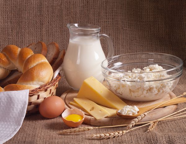 کوزه را با شیر تخم مرغ پنیر پنیر و کلوچه و نان در زمینه چاله بریزید