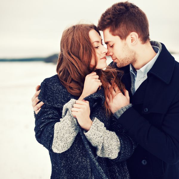 پرتره مد در فضای باز زن و شوهر جوان در آب و هوای سرد زمستان عشق و بوسه