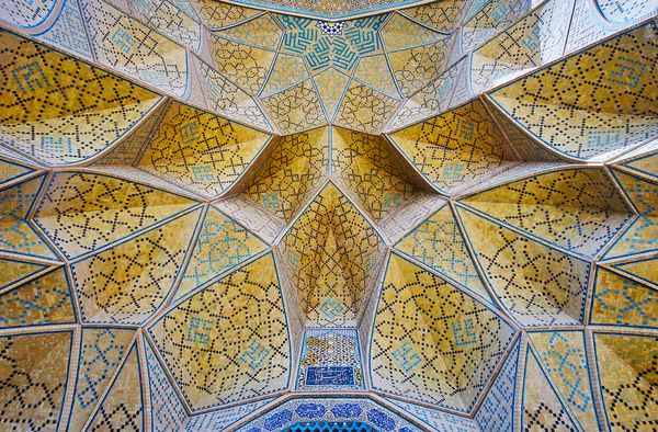 در نزدیکی قوس موکارنس لانه زنبوری درگاه غربی مسجد جامع سلولهای آجری با الگوهای موزائیک پیچیده پوشیده شده است اصفهان ایران