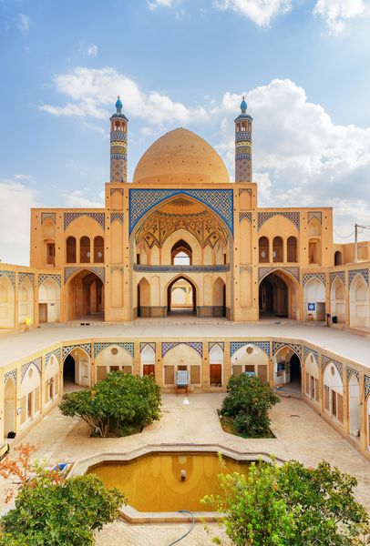 نمایی زیبا از مسجد آقا بزرگ در زمینه آسمان آبی در کاشان ایران معماری زرق و برق دار اسلامی مسجد تاریخی و مادریا از جاذبه های گردشگری محبوب خاورمیانه است