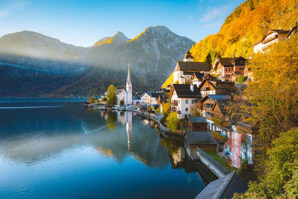 منظره عکس از کارت پستال زیبا از دهکده کوهستانی مشهور هالستات با Hallstatter در کوههای آلپ اتریش در نور آفتاب طلایی زیبا در پاییز منطقه Salzkammergut اتریش مشاهده کنید