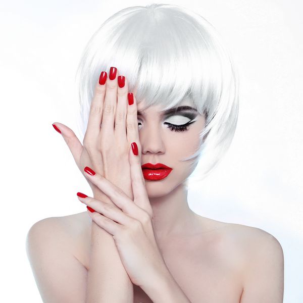 آرایش و مدل مو لب های قرمز و ناخن های مانیکور شده دختر زیبایی مد جدا شده در پس زمینه سفید