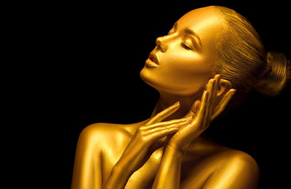 هنر مد پوست طلایی closeup چهره زن دختر مدل با آرایش حرفه ای براق و طلایی Glamour تعطیلات جواهرات طلا جواهرات لوازم جانبی بدنه فلزی طلای زیبایی پوست رنگی