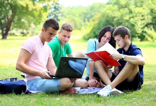 چهار دانشجوی خندان که در پارک سبز مشغول تحصیل هستند