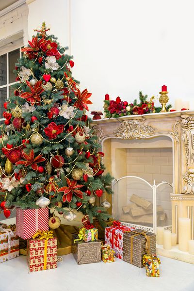 تزئین درخت کریسمس و جعبه های هدیه در اتاق نشیمن