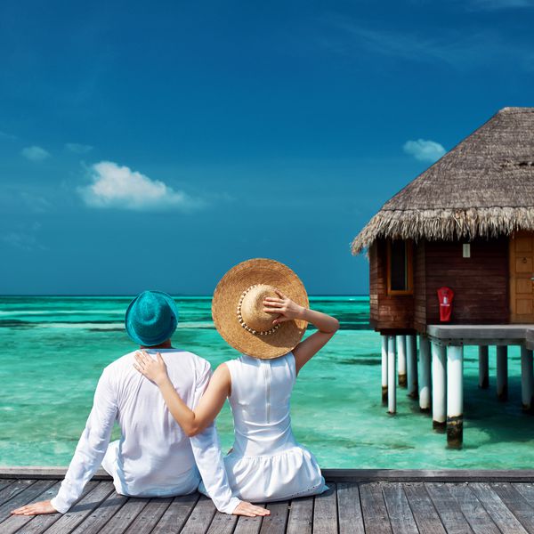 زن و شوهر در یک اسکله ساحل گرمسیری در مالدیو