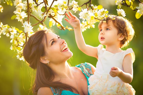 زن و کودک مبارک در باغ بهار شکوفه زن بوسیدن کودک مفهوم تعطیلات روز مادران