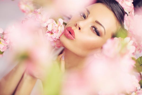 زن خندان زیبا با گلهای بهاری