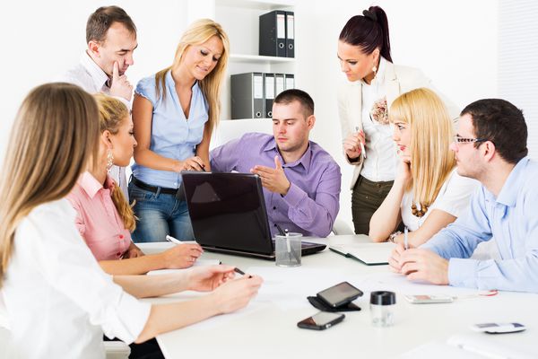 افراد شاد شغل در دفتر در مورد پروژه در مورد لپ تاپ در جلسه بحث می کنند