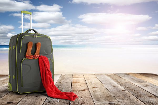 آفتاب تابستانی و چمدان با تزئین حوله قرمز