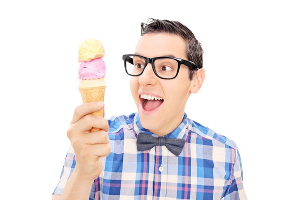 جوانی هیجان زده بستنی را که در زمینه سفید جدا شده نگه داشته است
