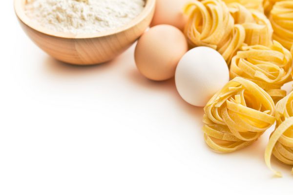 ماکارونی ایتالیایی تگلیاتل تخم مرغ و آرد روی زمینه سفید